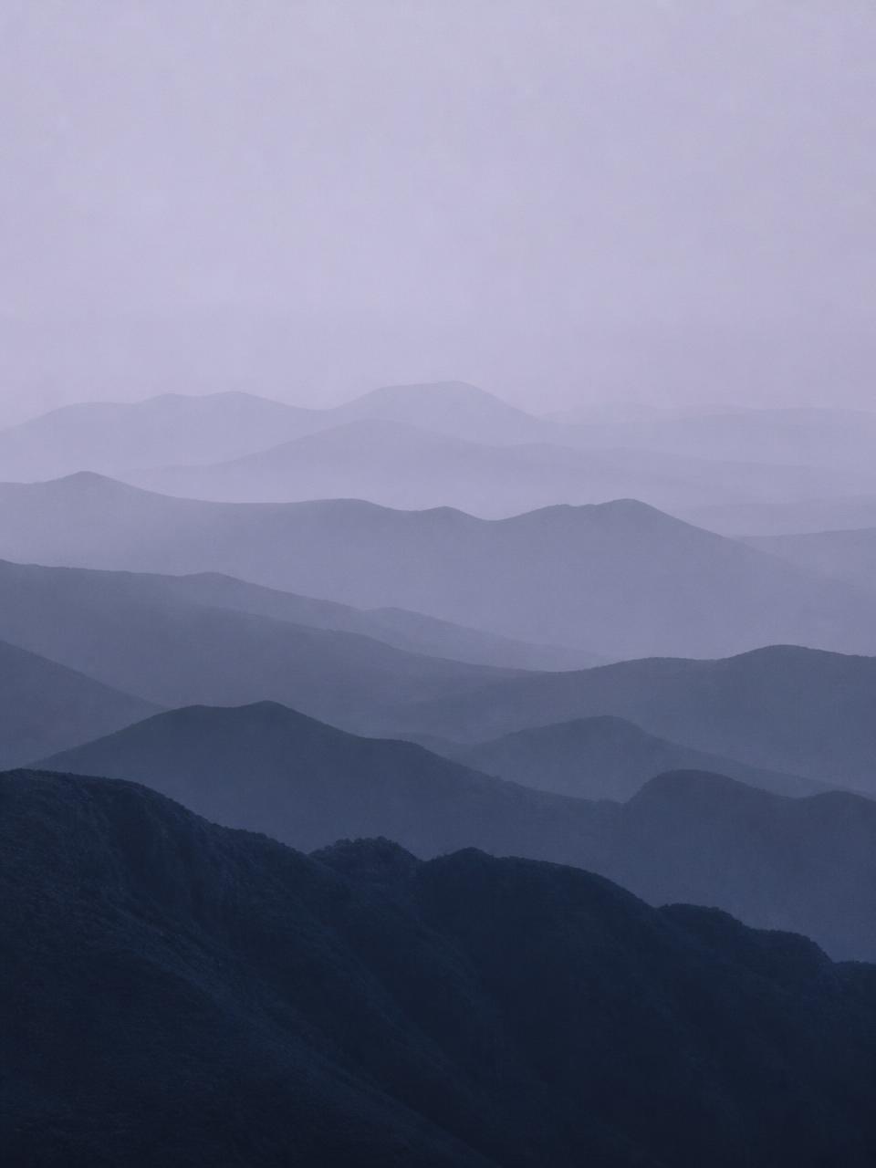Layered misty mountain ridges at dawn